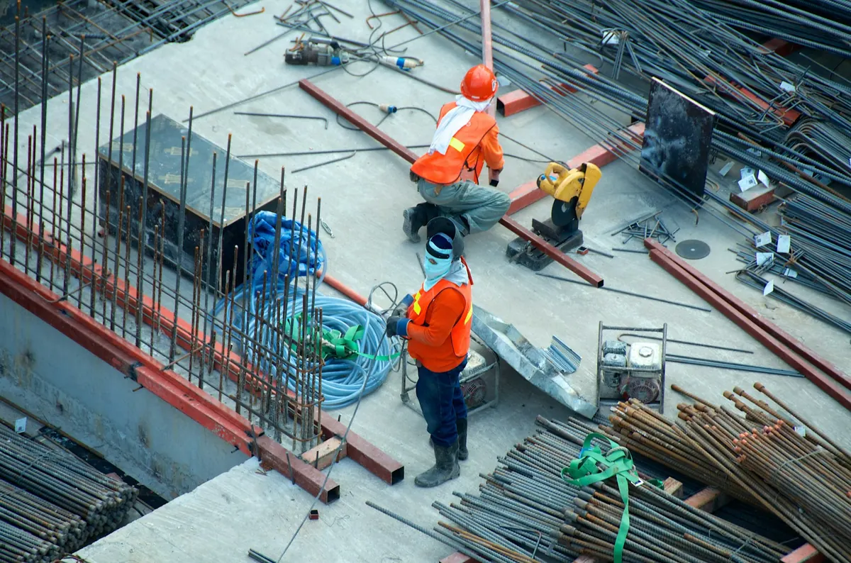 Construction workers on a concrete pour with rebar and equipment